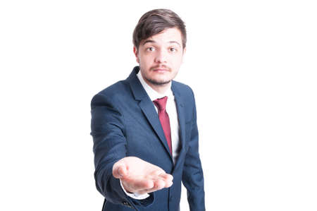 Sales man wearing suit making begging gesture with one hand isolated on white background with copy text spaceの写真素材