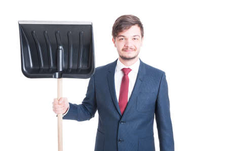 Man wearing suit standing holding or showing a snow shovel and smiling isolated on white backgroundの写真素材