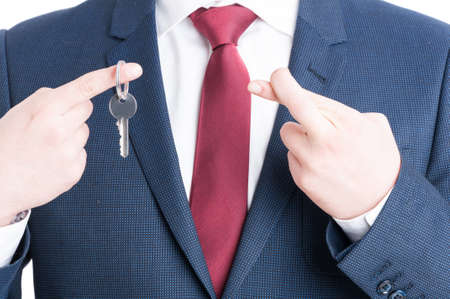 Close-up of real estate agent necktie showing keying and fingers crossed gesture isolated on white backgroundの写真素材
