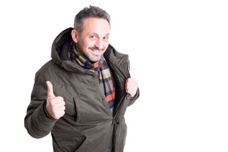 Male posing wearing winter jacket showing like gesture or thumb up isolated on white background with copy text spaceの写真素材