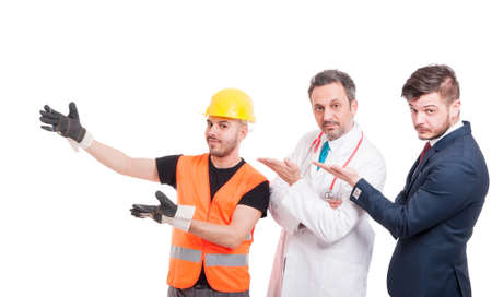 Group of three handsome men presenting something and smiling isolated on white studio backgroundの写真素材