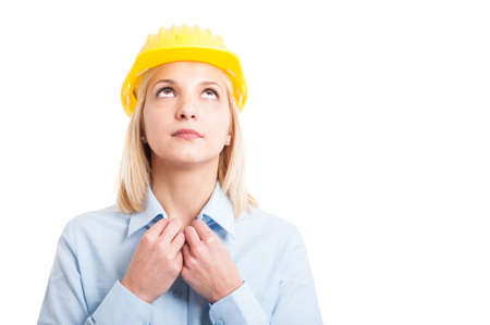 Portrait woman architect arranging her shirt looking up isolated on white background with copy text spaceの写真素材