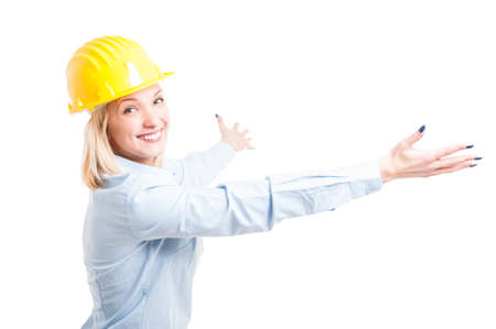 Lady engineer wearing helmet posing with arms open and smiling isolated on white background with copy text areaの写真素材