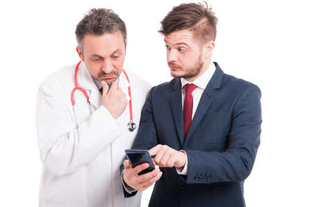 Successful ceo and young medic or doctor browsing something on cellphone isolated on whiteの写真素材