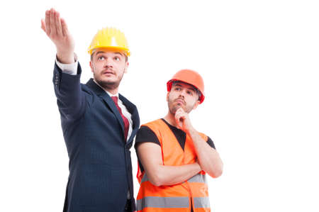 Bussinesman explaining and indicate something to young builder on white backgroundの写真素材