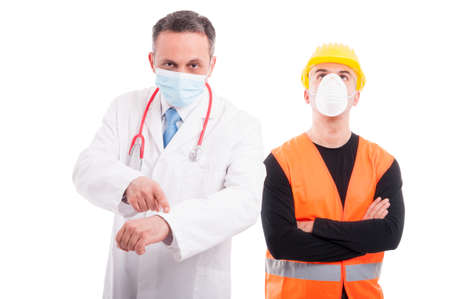 Doctor showing time and constructor ignoring or being passive looking up isolated on white backgroundの写真素材