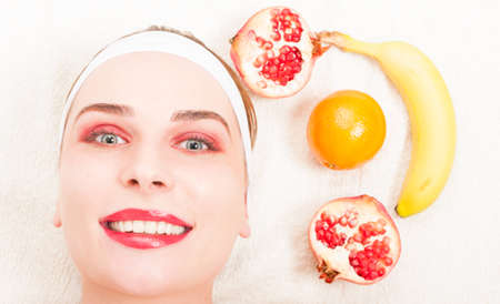 Natural homemade fruit facial mask with young female and fresh fruitsの写真素材