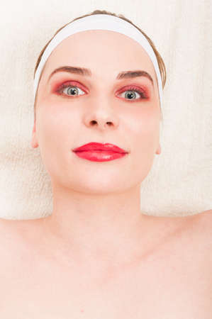 Beautiful young woman with perfect fresh skin relaxing in spa salon on white backgroundの写真素材