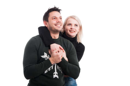 Attractive young female embracing his boyfriend from behind on white background with text spaceの写真素材