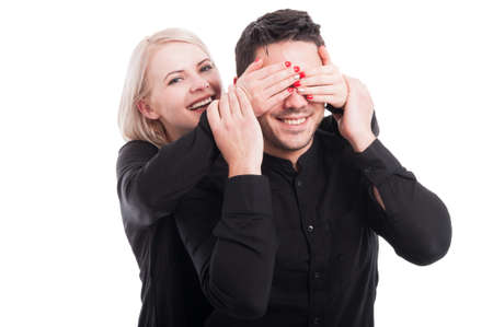 Happy young female surprising her boyfriend from the back isolated on white backgroundの写真素材