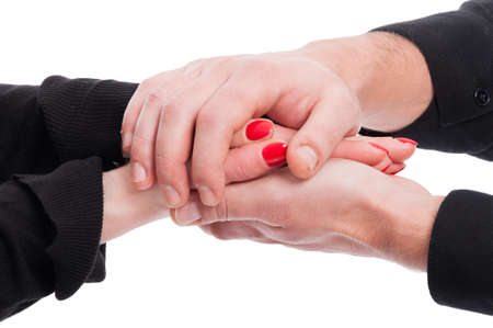 Man and woman holding hands in closeup protectively as trust and tenderness concept isolated on...