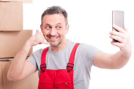 Mover guy making calling gesture taking selfie and smiling isolated on white backgroundの写真素材