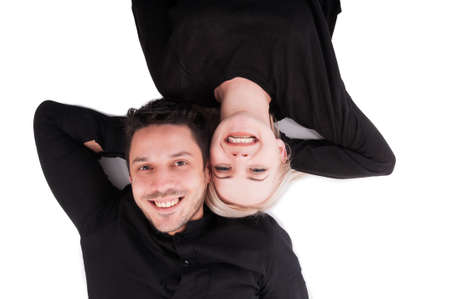 Happy couple lying down on the back and having fun together in top view isolated on white background