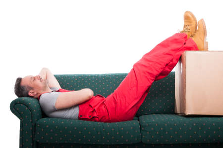 Mover man resting laid down on couch with feet up isolated on white backgroundの写真素材