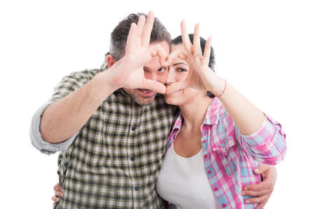 Couple in love showing heart symbol with their fingers as passion concept isolated on whiteの写真素材