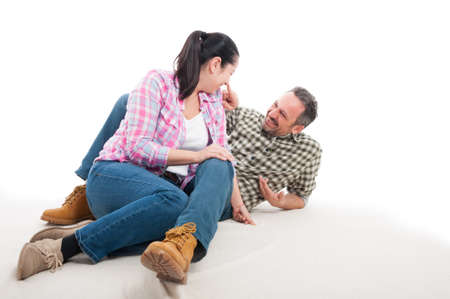Happy man and woman sitting relaxed on floor having great time together isolated on white backgroundの写真素材