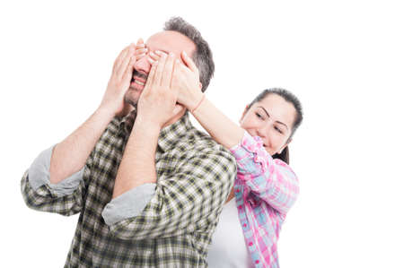 Beautiful young loving couple with female holding hands on man eyes isolated on whiteの写真素材