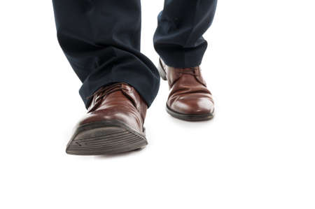 Close-up of business man elegant shoes walking isolated on white backgroundの写真素材