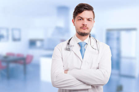 Portrait of attractive doctor holding arms crossed and looking at the camera with advertising areaの写真素材