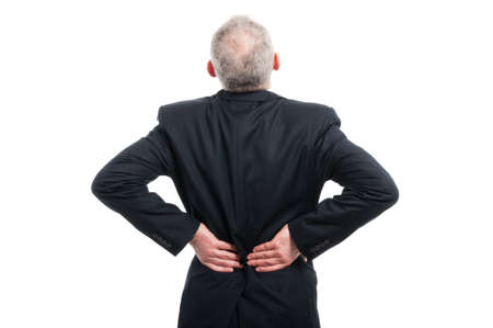 Back view of senior holding his back like hurting wearing suit and tie isolated on white background...