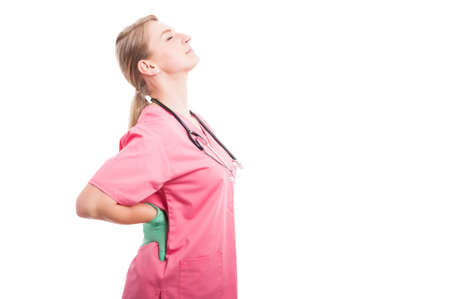 Female medical nurse holding her back like hurting isolated on white background with copy text spaceの写真素材