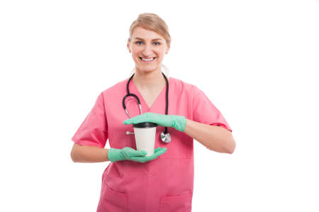 Blonde medical nurse lady holding takeaway coffee cup and smiling isolated on white backgroundの写真素材