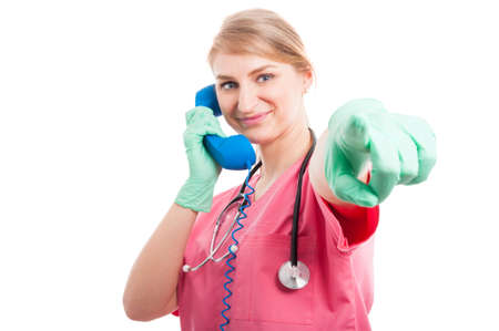Medical nurse lady holding receiver and pointing camera isolated on white background with copy text spaceの写真素材