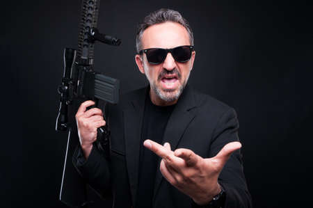 Aggressive gangster with rifle fighting or screaming at somebody
