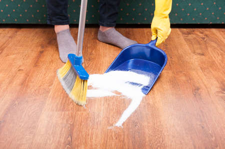 Housekeeping lady cleaning the mess from the floom in closeup view