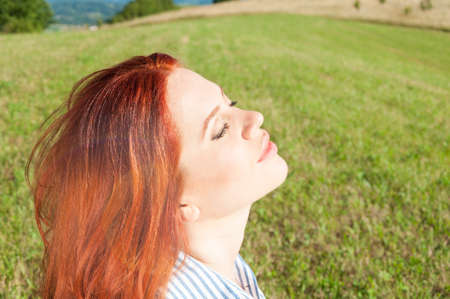 Woman relaxing and enjoying the sun while breathing fresh air outdoors