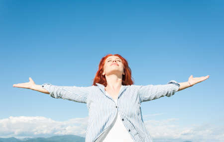 Beautiful calm woman enjoying summer outdoors as freedom and peace conceptの写真素材