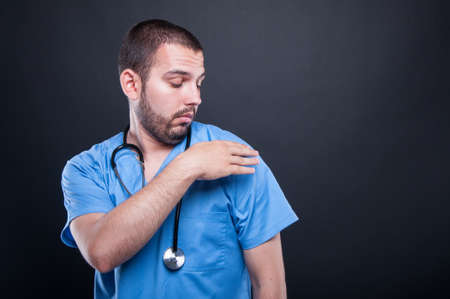 Doctor with stethoscope cleaning his shoulder on black background with copy text spaceの写真素材