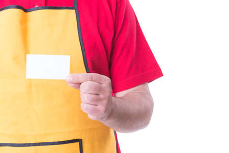 Salesman with apron showing empty visit card isolated on white background with text spaceの写真素材