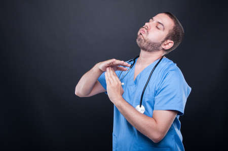 Tired doctor wearing scrubs with stethoscope making time out gesture on black background with copy text spaceの写真素材