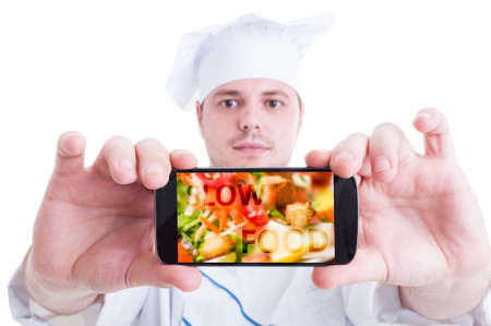 Cook or baker showing smartphone with healthy food or fresh saladの写真素材
