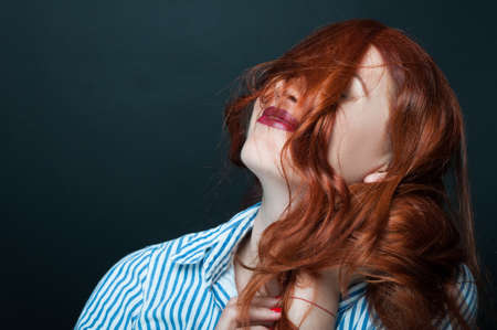 Beautiful female model with make-up and lipstick looking relaxed and happyの写真素材