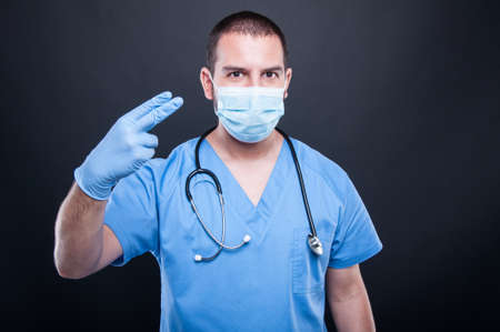 Portrait of proctolog wearing latex gloves gesturing procedure on black backgroundの写真素材