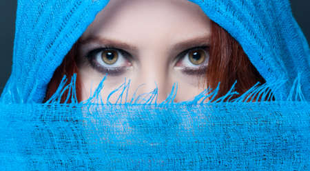 Sensual eyes of mysterious woman behind scarf in close-up
