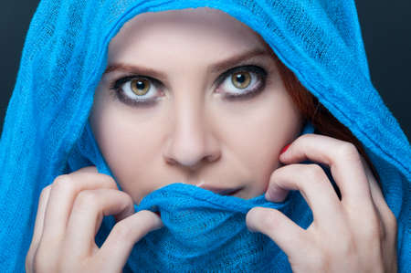 Glamour female model with headscarf posing on dark backgroundの写真素材