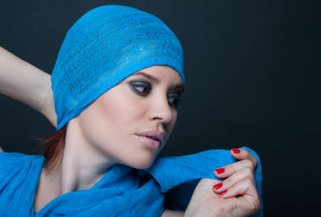 Stylish young woman with trendy look and makeup posing seductive on dark backgroundの写真素材