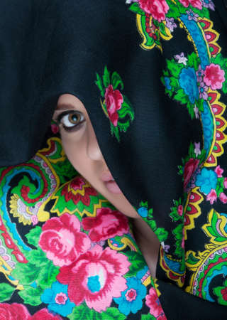 Gorgeous woman having face covered by long floral scarf looking mysteriousの写真素材