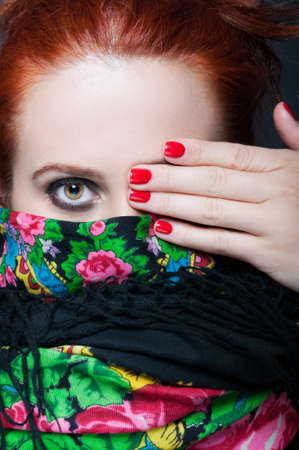 Closeup view of stylish woman covering her eye and wearing scarfの写真素材
