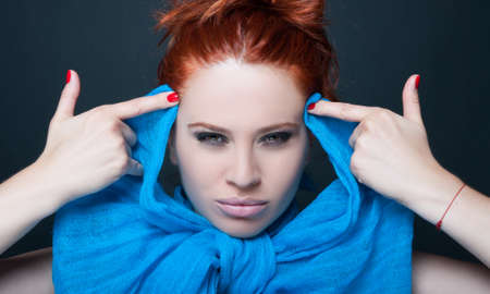 Portrait of beautiful woman blowing mind with finger doing gun gesture on dark backgroundの写真素材