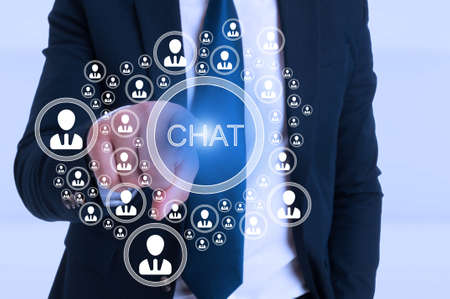Business man pointing the chat button from modern interface as social media conceptの写真素材