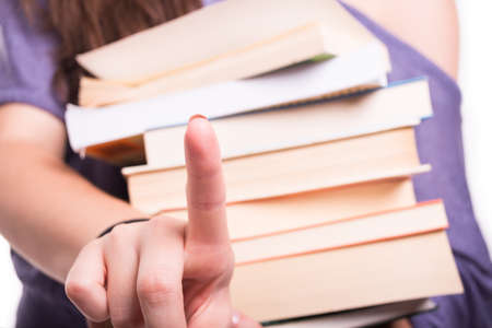 Girl student finger touching the screen glass and holding books in close-up