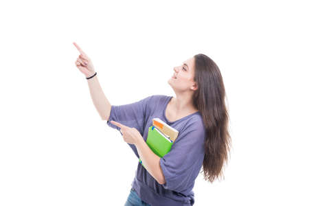 Happy university student holding books and pointing to the left on white background