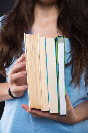 College girl showing her books at the camera in closeup viewの写真素材