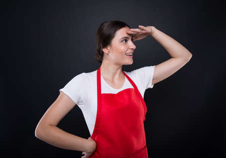 Side view of young employee girl looking at something high and far awayの写真素材