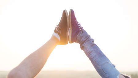 Beautiful couple in love standing outside in the nature and touching each other feetの写真素材