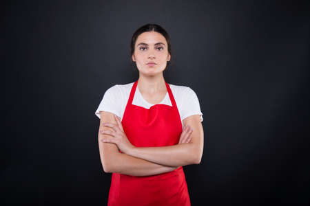 Portrait of serious seller with crossed arms posing confident on dark backgroundの写真素材